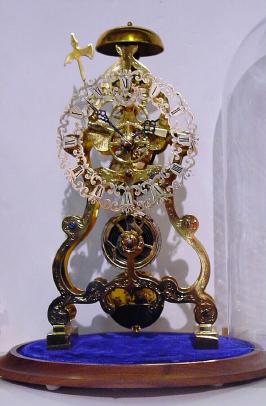 Mid 20th Century, English, Passing Strike Skeleton clock in a scroll style frame with profuse engraving on the front plate. — Antique Clocks Price Guide