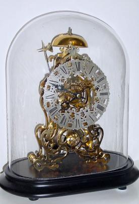 Mid 20th Century, English, Passing Strike Skeleton clock in a scroll frame patterned after the famous Arabesque by Evans, considered the most beautiful skeleton clock model. — Antique Clocks Price Guide