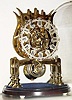 Mid 20th Century, English, Passing Strike Skeleton clock in a lyre style frame with engraving on the front plate.