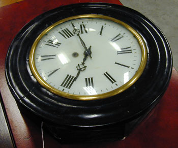 A BLACK PAINTED AND ENAMEL WALL CLOCK. — Antique Clocks Price Guide