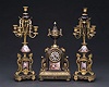 A GILT BRONZE MOUNTED 'JEWELED' 'SEVRES' COBALT-BLUE GROUND PORCELAIN CLOCK GARNITURE, late 19th/early 20th century.