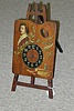 A PAINTED WOOD EASEL-FORM TABLE CLOCK, early 20th century.