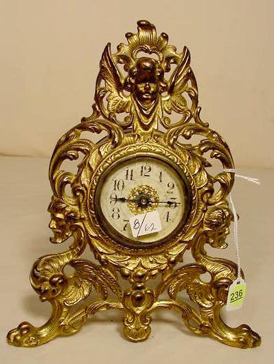 Figural cherub &amp; man/dragon metal desk clock: — Antique Clocks Price Guide
